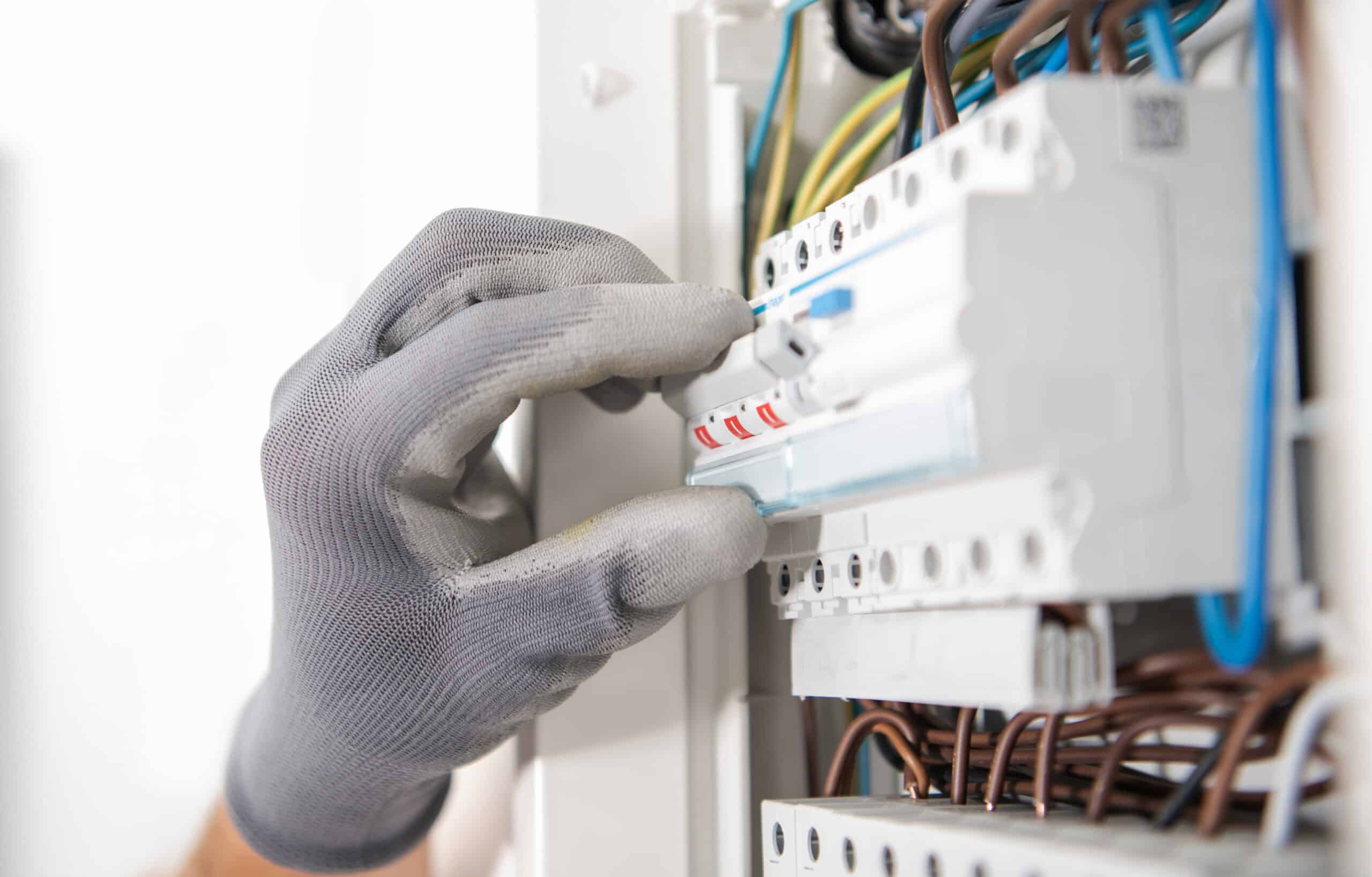 Elektriker prüft Sicherungen im Verteilerkasten